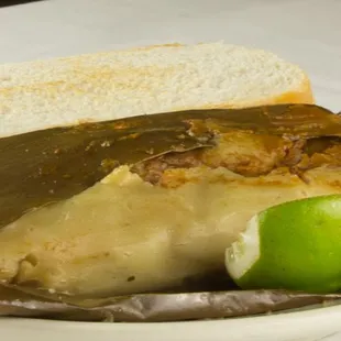 Corn Tamale Stuffed with Pork, Olives, Red Peppers Steamed in banana leaf served with French Bread - The Guatemalan &amp; Salvadorian Style!