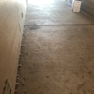 Dust bunnies and cigarette butts collected outside room doors.