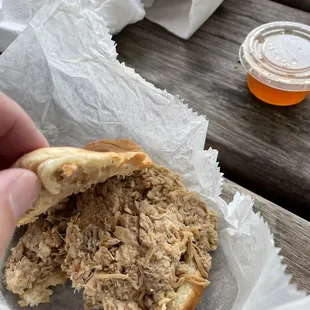 a pulled pork sandwich with a bite taken out of it