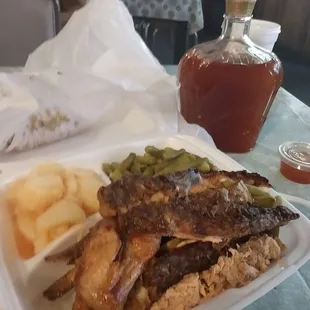 Combo plate with potatoes and green beans. And...their awesome sauce that you can only get there. On the table. In a Crown Royal bottle