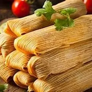 a pile of tamales on a cutting board