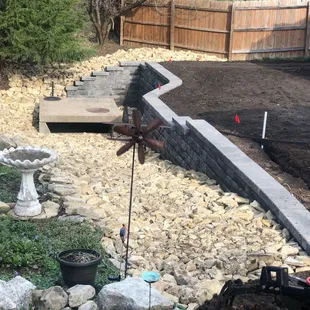 a garden with a stone retaining wall