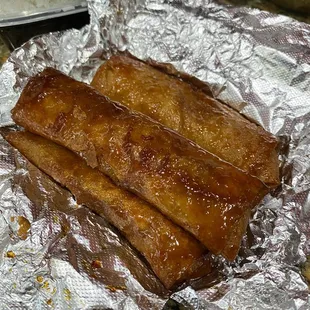 two pieces of pork wrapped in tin foil