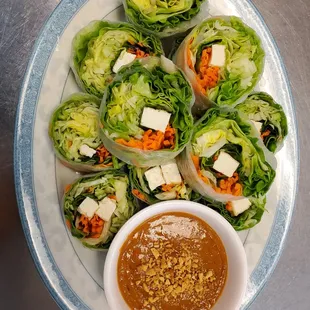 a plate of lettuce wraps with dipping sauce