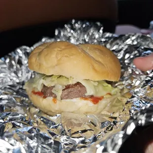 Cheeseburger with lettuce and tomato with ketchup and mayonnaise.