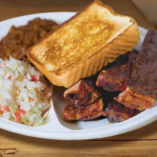 a plate of ribs, coleslaw, and a grilled cheese sandwich