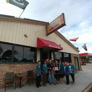 a group of people cutting a ribbon
