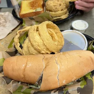 roast beef poboy and onion rings in front. club and onion rings in the back.