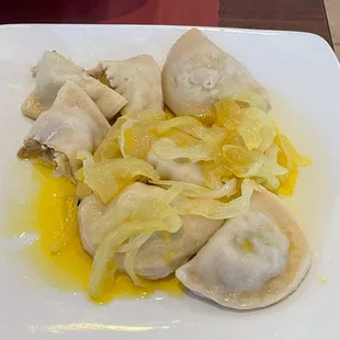 Yummy pillow-soft mushroom sauerkraut pierogis with butter and onions