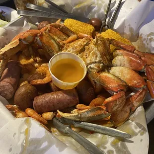 crab legs, potatoes, corn, and mustard