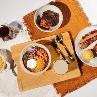 a plate of ribs, macaroni and cheese, a bowl of macaroni and cheese