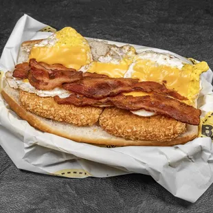 a fried chicken sandwich with bacon and eggs