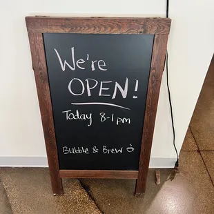 a chalk board with a sign that says we&apos;re open