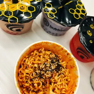 a bowl of noodles and two cups of drink