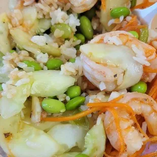DIY Poke Bowl with rice, shrimp, salmon, carrots, cucumber, edamame, teriyaki, and sweet chili
