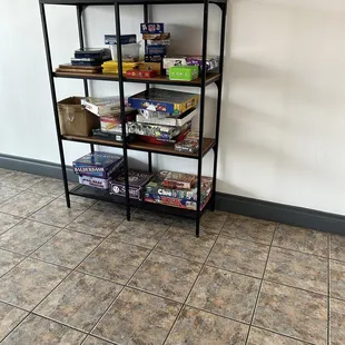 a shelf of board games on a tiled floor