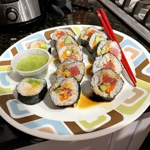 a plate of sushi with chopsticks