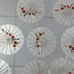 white umbrellas decorated with red flowers