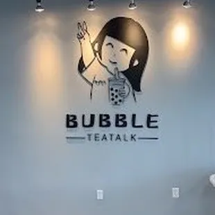 a woman sitting on a chair in front of a sign that says bubble tea talk