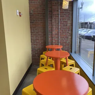 a bright orange table and yellow stools