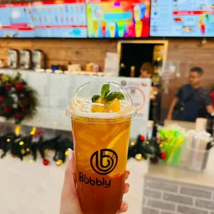 a hand holding a cup of iced tea