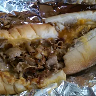 Two cheese cheesesteak with cheddar cheese, fried onions, mayonnaise, and whiz.