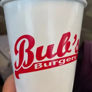 a hand holding a paper cup