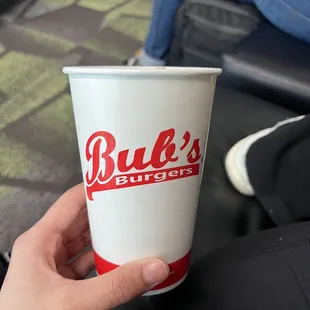 a hand holding a paper cup