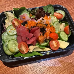 a salad in a plastic container on a wooden table