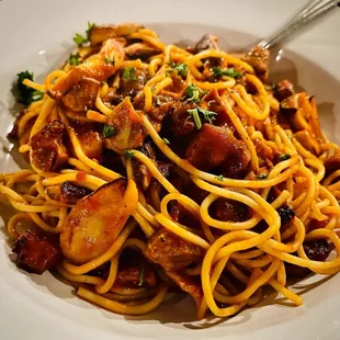 a plate of spaghetti with meat and vegetables