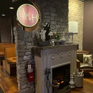 a fireplace with a neon sign above it