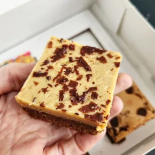 a hand holding a piece of brownie