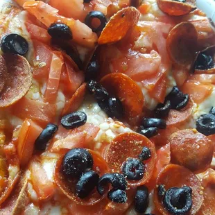 Personal pizza with pepperoni, tomato, black olive.