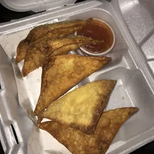 three pieces of fried food in a styrofoam container