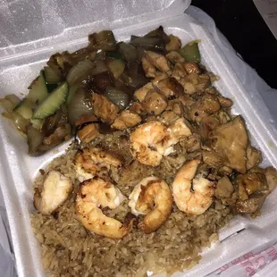 a styrofoam takeout box with rice, mushrooms, and chicken