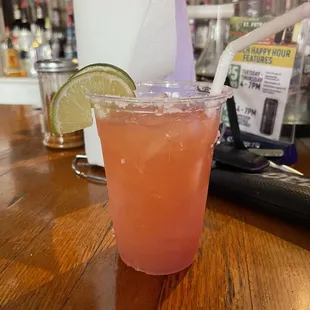 a drink with a straw and a lime slice