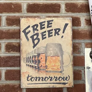 a beer sign on a brick wall