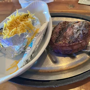 Baked potato and tenderloin wrapped in bacon.