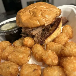 Smoky garlic pulled pork sandwich with tater tots