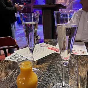two glasses of champagne and a bottle of orange juice