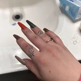 a woman's hand with red and green nail polish