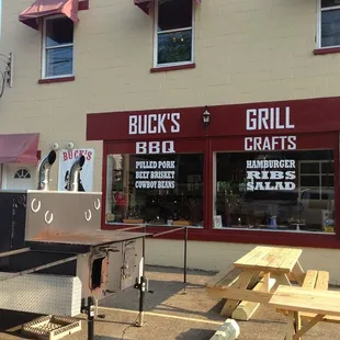 Front of business, smoker and picnic tables. Additional seating inside.