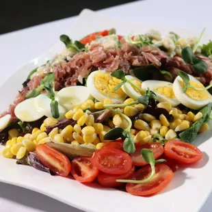Kentucky Cobb
Baby greens tossed in spiced peach vinaigrette, with egg, country ham, tomato, bleu cheese crumbles, corn, diced peppers