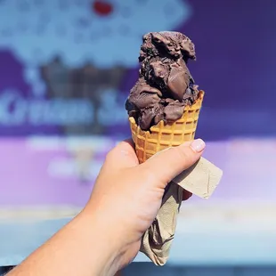 a hand holding an ice cream cone