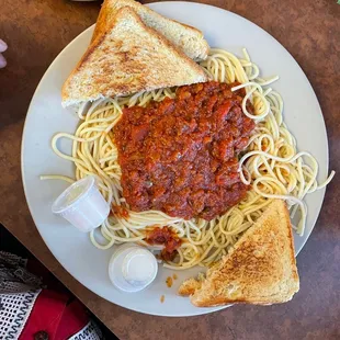 a plate of spaghetti and toast on a table