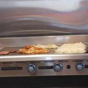 Grill with burgers and breakfast items.