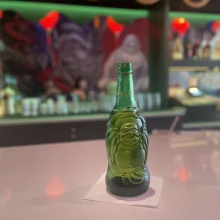 a green beer bottle on a bar counter