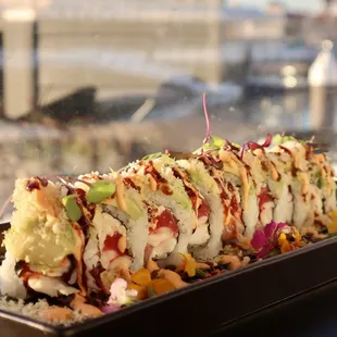OMF Roll Tuna, yellowtail, shrimp, kani kama, masago topped with avocado, spicy mayo, eel sauce and tempura flakes