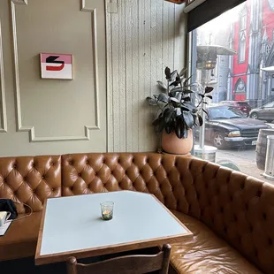 a corner booth with a table and chairs
