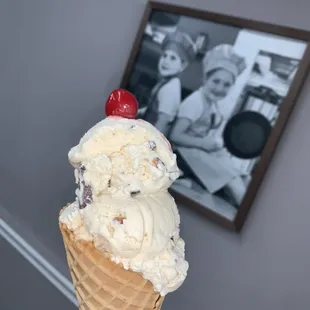 an ice cream cone with a cherry on top